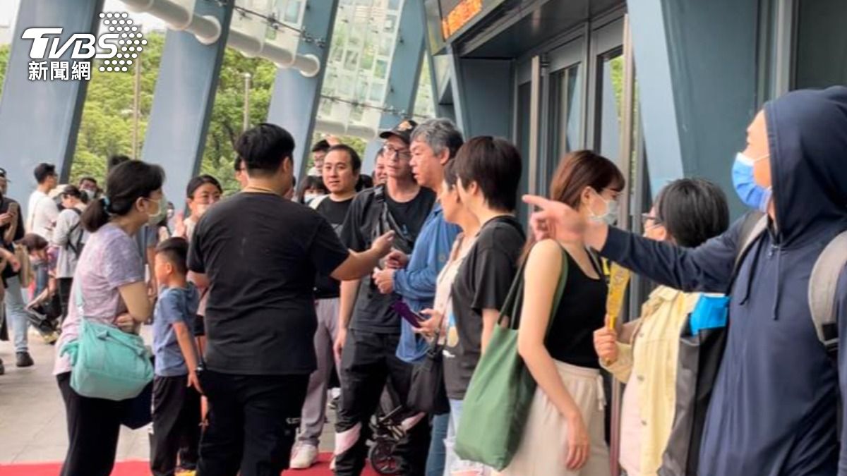黑衣工作人員(左二)拿影片仔細比對排隊人龍。(圖/陳薈涵攝)