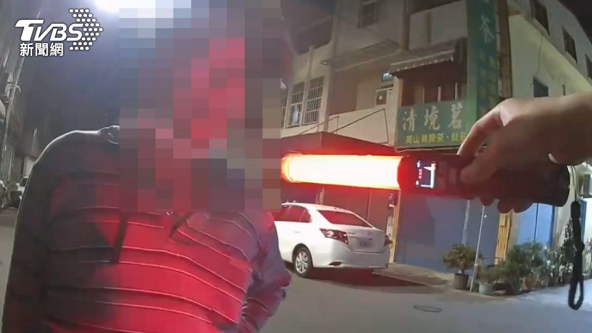 警方拿酒測器來的檢測的時候，又有另一名未扣帽扣的機車騎士呼嘯而過。（圖／TVBS）