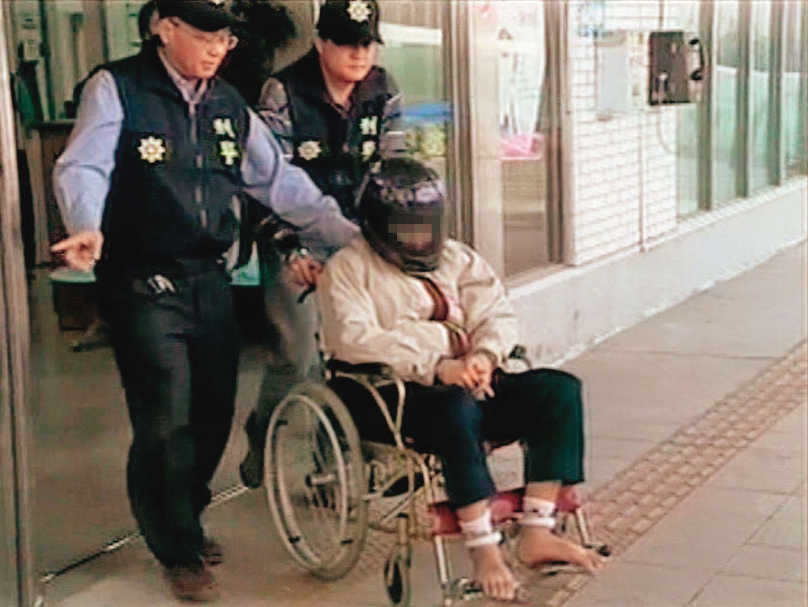 黃姓凶手（坐者）被警方借提時，假裝癲癇、行動不便，最後遭戳破謊言。（圖／東森新聞提供）