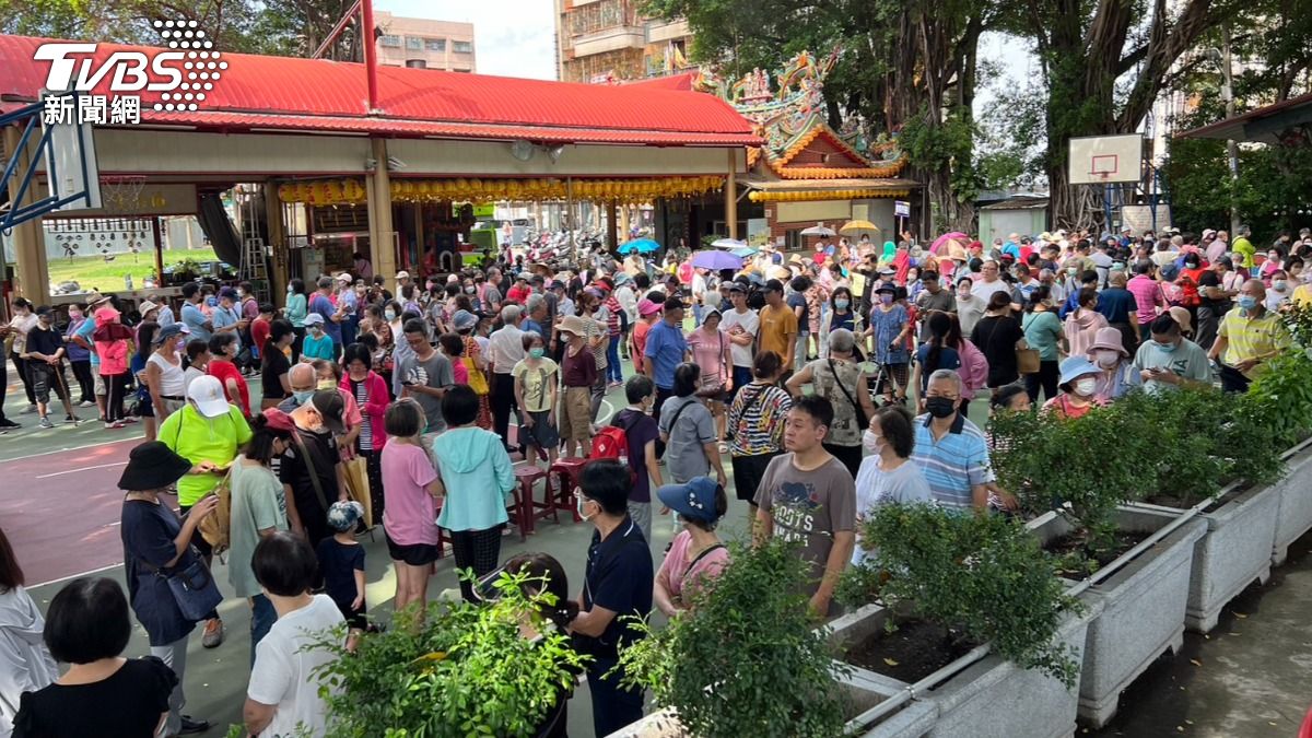 許多長輩紛紛撐傘,揮舞扇子來消暑,2千5百份約1小時左右就發完。(圖/林冠丞攝)