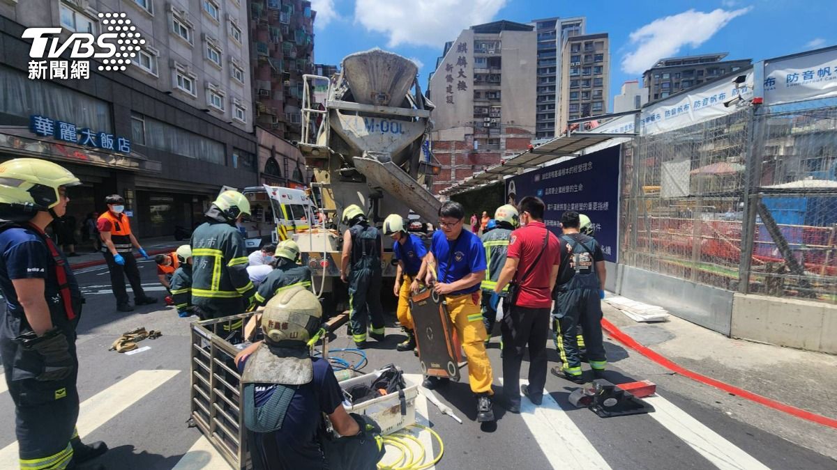 婦人穿越馬路時遭水泥車撞輾受困車輪底下,大批警消人員到場搶救。(圖/TVBS)