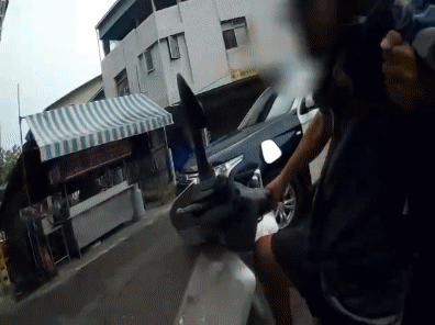 游男緊握機車把手,人卻未坐在座墊,僅用雙腳撐住身下的機車。(圖/TVBS)