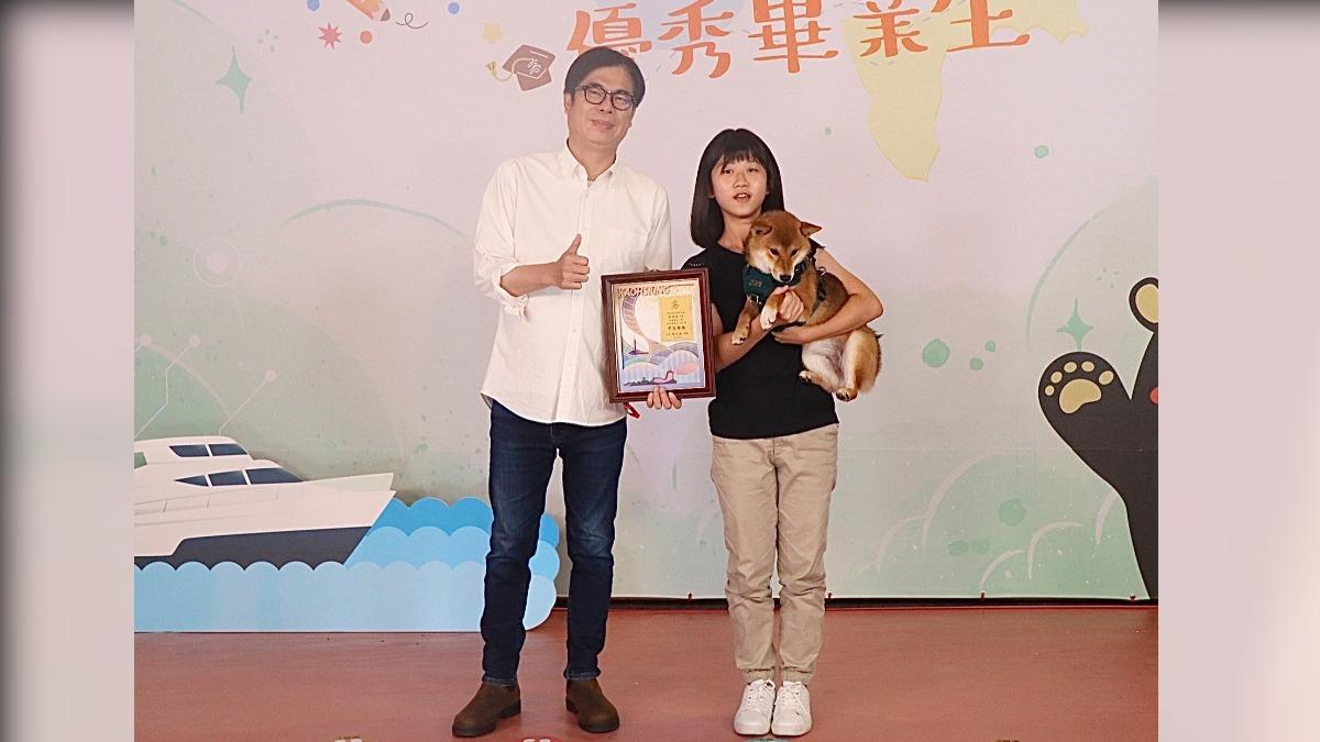 旗山國小張煊翊同學帶著柴犬「貝果」與市長陳其邁合影，一起分享她的榮耀。