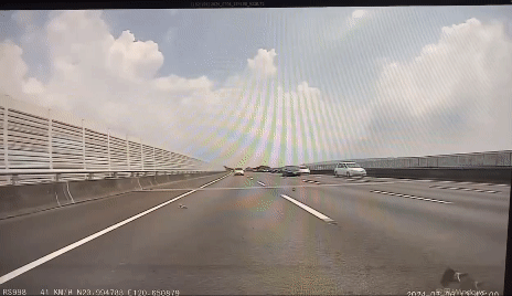 該名駕駛下車撿拾,還不斷閃過轎車,趁空檔再走入車道撿掉落物。(圖/翻攝自臉書「草屯人」)
