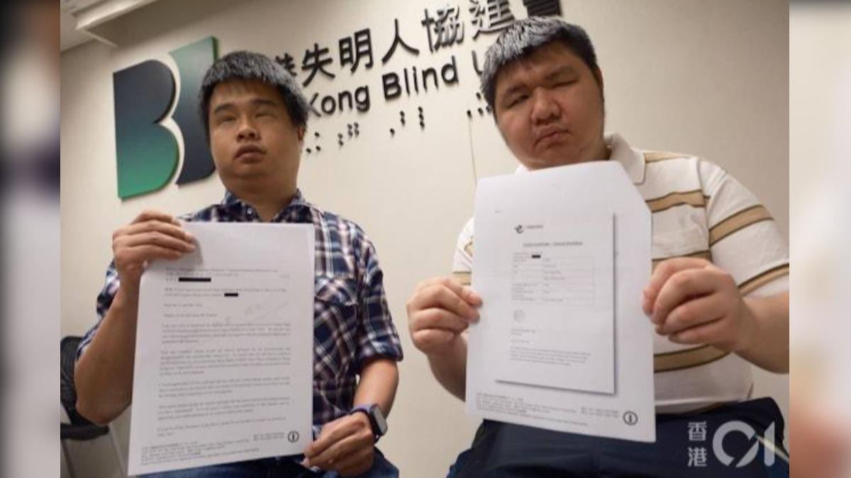 兩名被趕落機的視障人士李俊彥(左)和徐文俊,手持HK Express以電郵文件解釋當日事件經過。(圖/香港01提供)