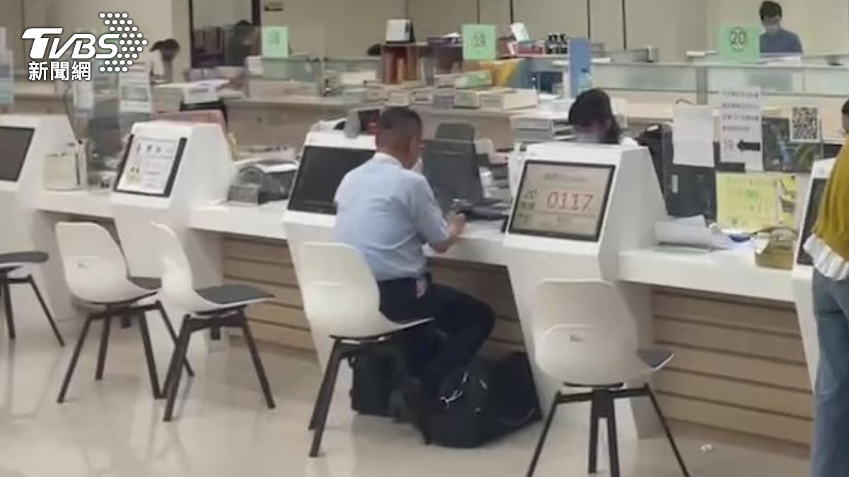 鄭文燦律師拿著千鈔磚頭給櫃檯點交。（圖／葉志明攝）
