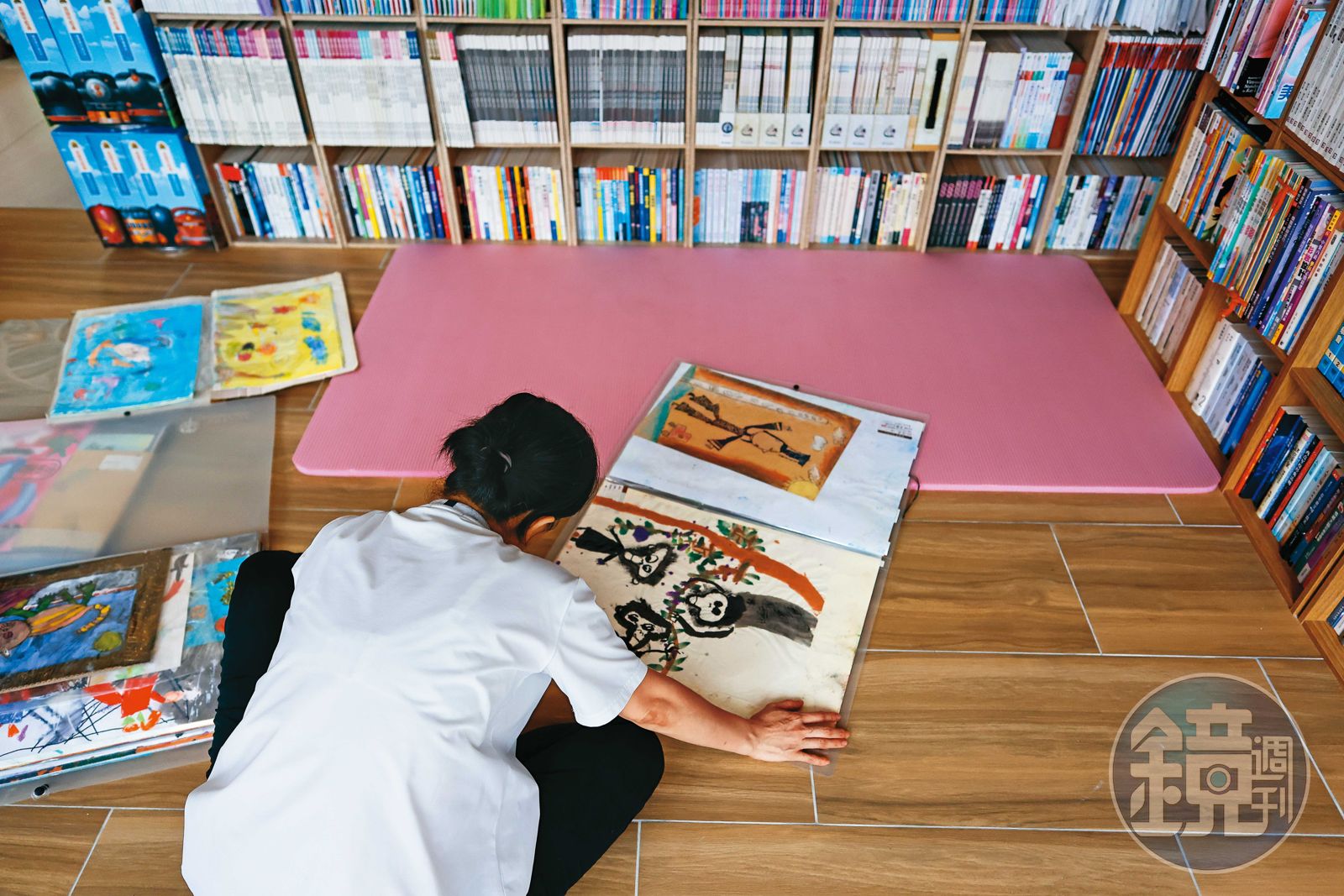 小宇的母親翻著小宇幼時畫作,可看出他極具天賦。(圖/鏡週刊)
