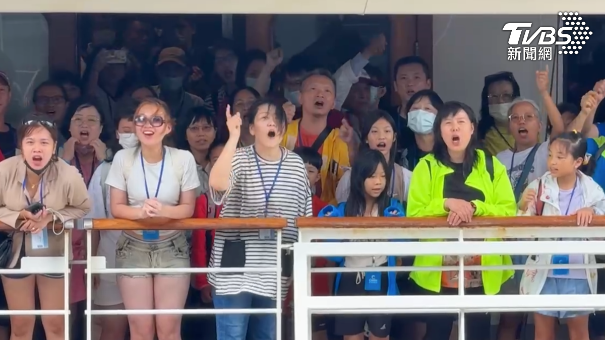 船上旅客相當不滿,在停靠高雄旅運中心時衝上甲板大聲抗議。(圖/TVBS)