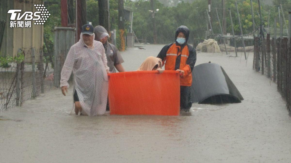 豪雨導致屏東多處淹水,警消人員用塑膠箱充當船艇救援受困民眾。(圖/TVBS)