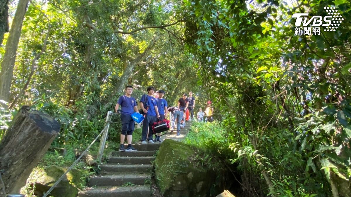 警消人員頂著大熱天上山搜救,最後將洪姓山友平安搬運下山並送醫救治。(圖/TVBS)