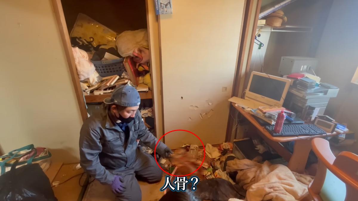 人員抓起一根長長物體，仔細端倪嚇得直喊「人骨？」（圖／翻攝自スッキリンお片付けチャンネルYT）