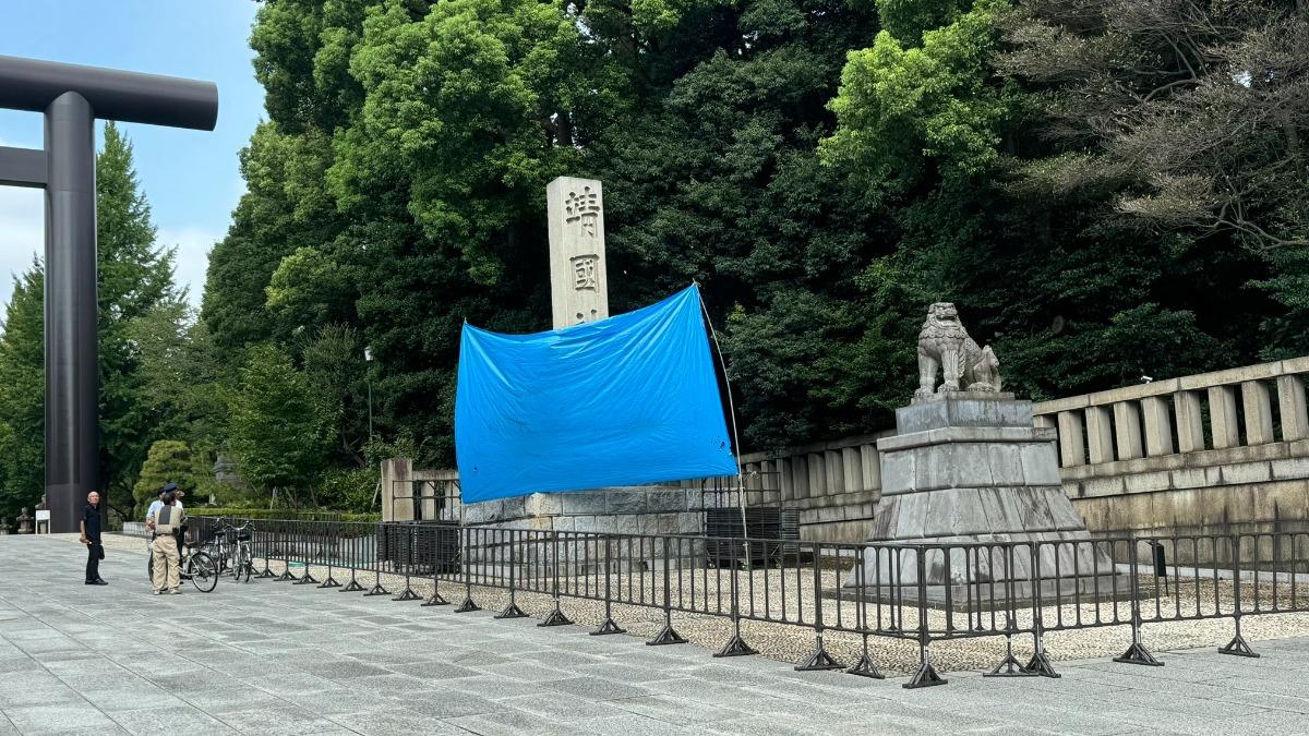 靖國神社遭塗鴉的石柱目前已用藍色幕簾遮擋起來。(圖/翻攝自X@Yasuo_Yano)