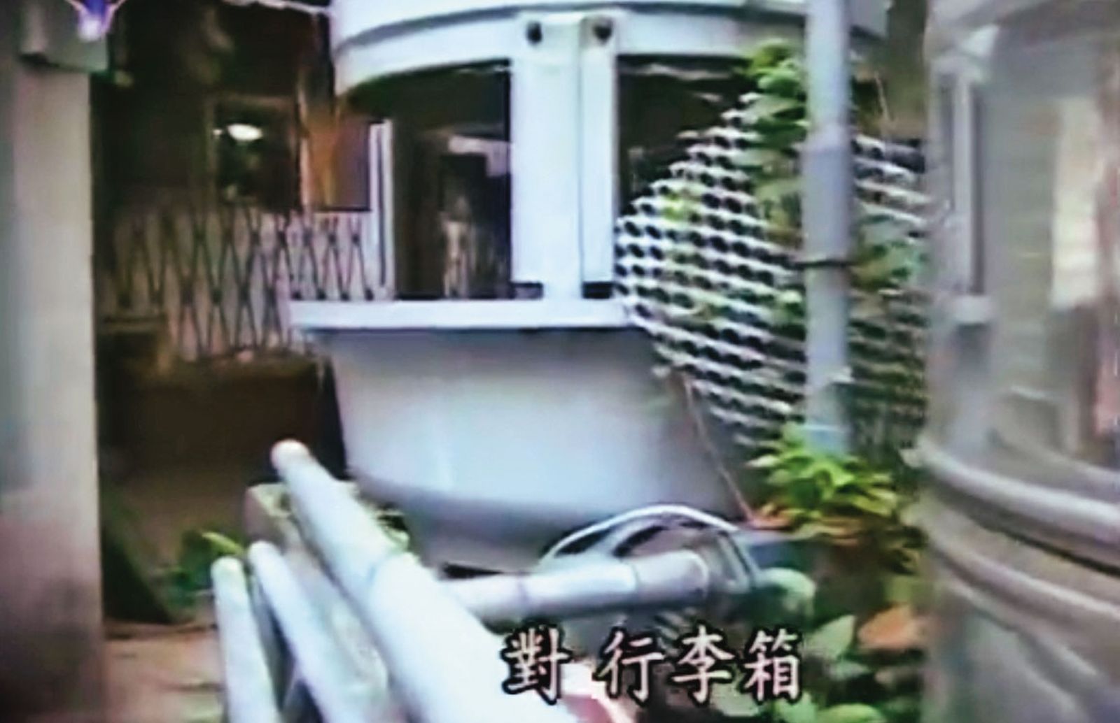警方在水塔與牆壁的縫隙中,發現裝有屍體的行李箱。(圖/翻攝自東森新聞)