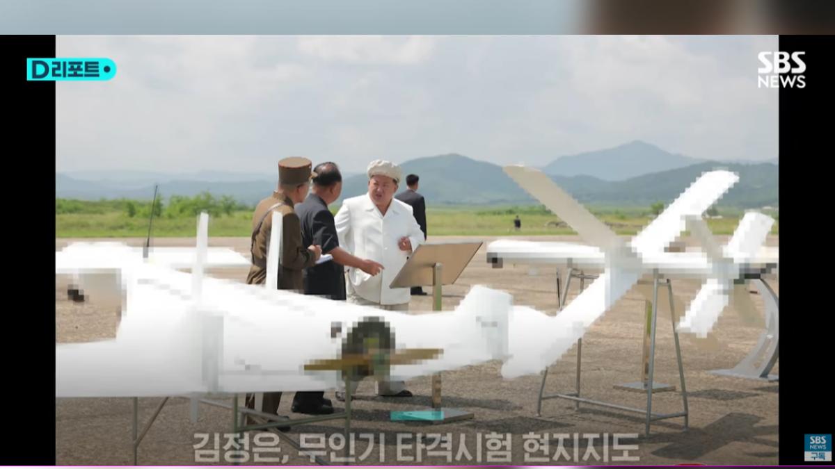 北韓最高領袖金正恩(中)親自校閱無人機測試,全白新造型卻意外搶眼。(圖/翻攝自SBS新聞影片)