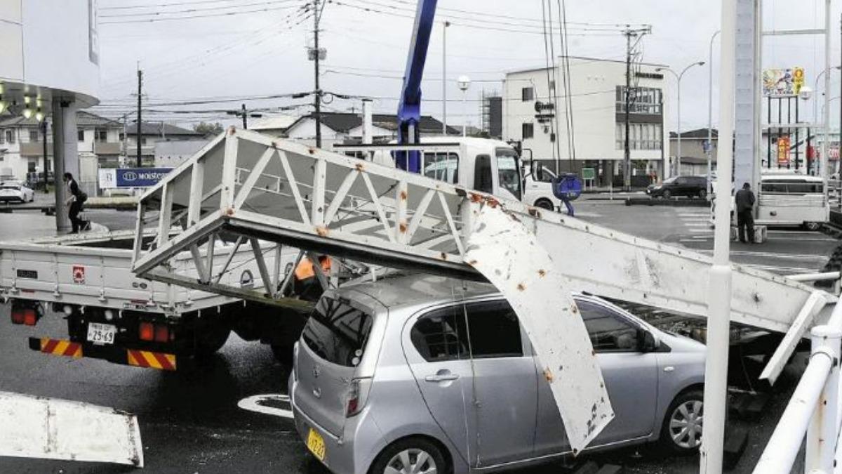 宮崎市大塚町的停車場看板被吹倒,重砸下方轎車。(圖/擷取自讀賣新聞)