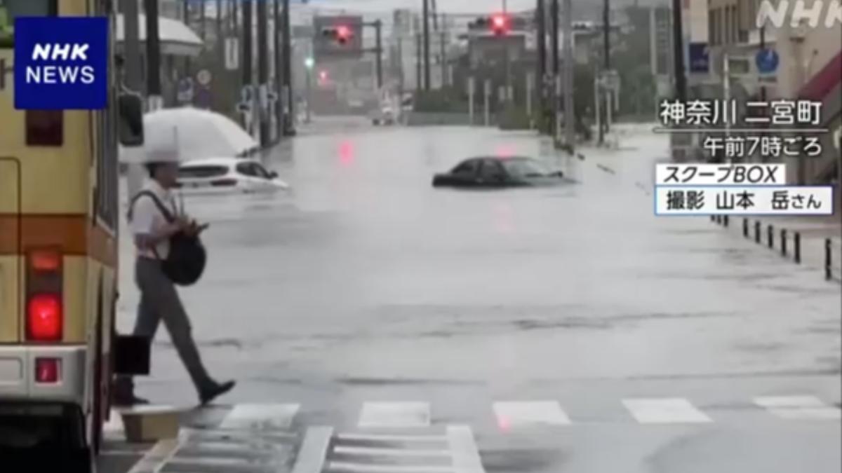 神奈川二宮町，有2輛車行駛在道路上的車輛因暴雨而被淹沒。（圖／翻攝自NHK）