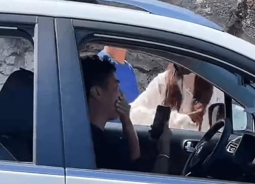 霸道逆向女狂打車內男子,他疼痛摀著嘴。(圖/翻攝自微博)
