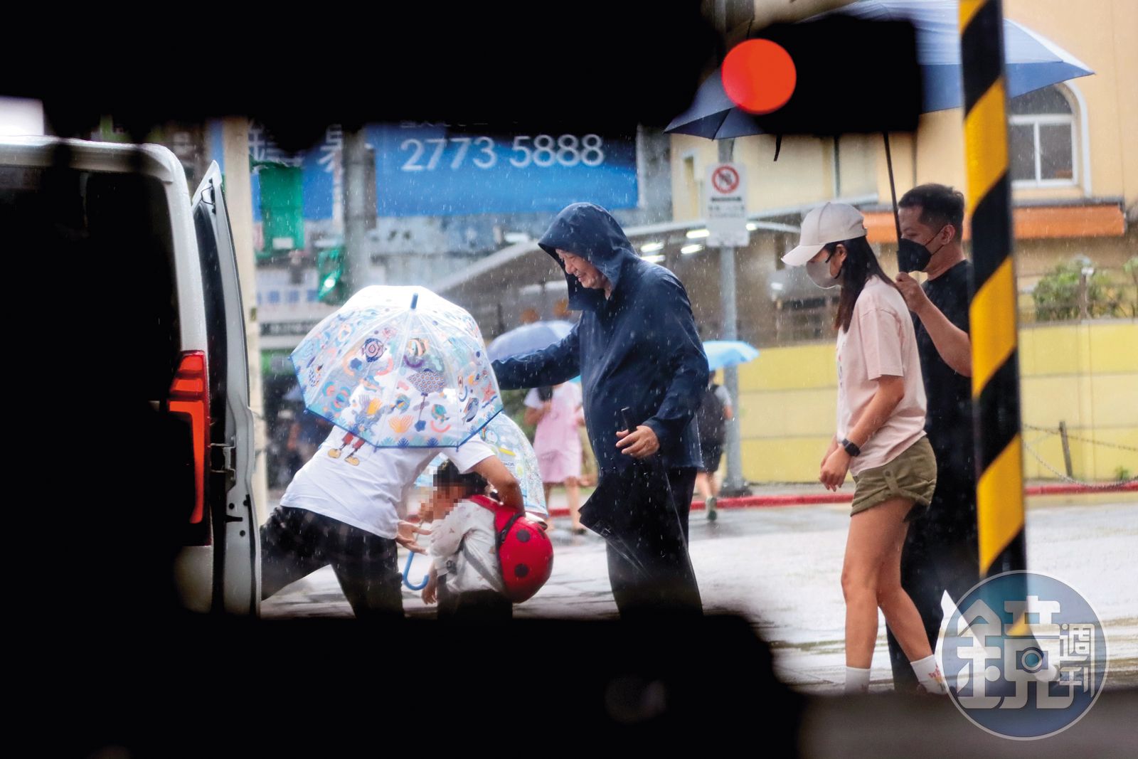 8/15 16:21 移工(左一)先把未滿4歲的妹妹抱上車,幼兒園師長(中)也來照應。(圖/鏡週刊)