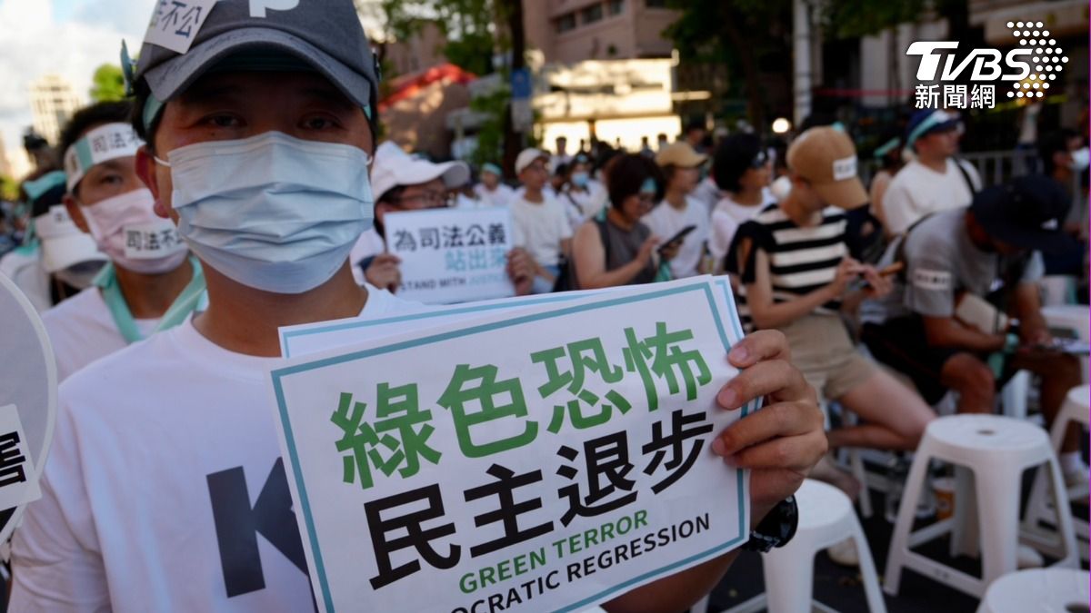 民眾舉起「綠色恐怖」文宣。(圖/區國強攝)