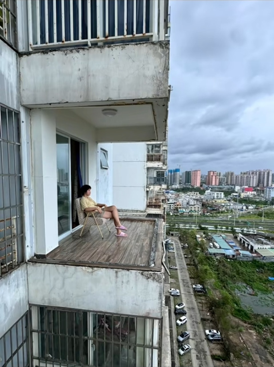 該名少女淡定坐在無邊框露臺上休息,影片一出意外爆紅。(圖/翻攝自微博)