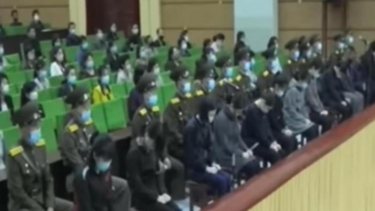因觀看韓劇被公開戴上手銬被捕,少女們低著頭坐在前排。(圖非此次事件/翻攝自KBS News YouTube)
