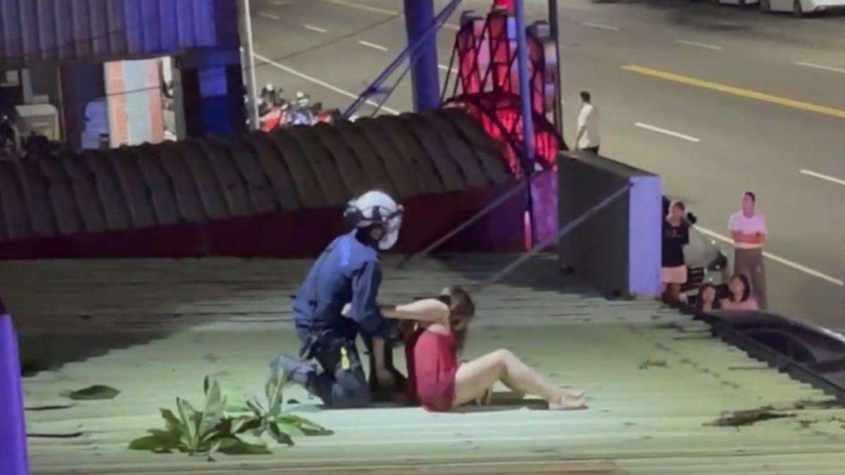 救援過程中女子不斷掙扎，警消險些拉不住人，所幸最後順利救援成功。（圖／翻攝自記者爆料網）