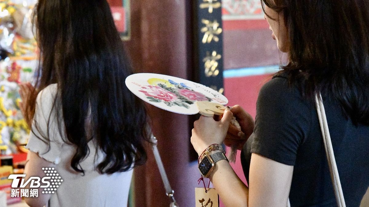 民眾手持彩繪扇頁。（圖／胡瑞麒攝）