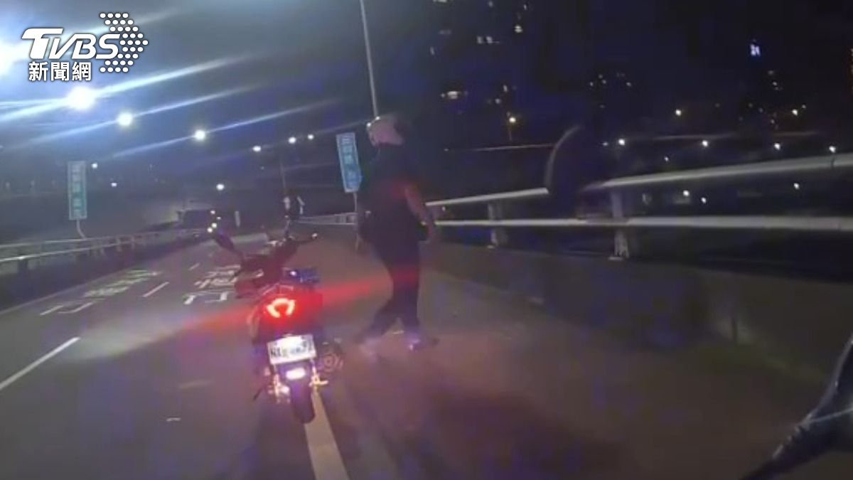 男子心情不佳坐在台北橋欄杆邊看風景散心。(圖/TVBS)
