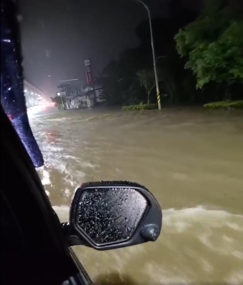 淡水路面積淹水嚴重,車輛經過都會掀起浪花。(圖/翻攝自陳家琪臉書)