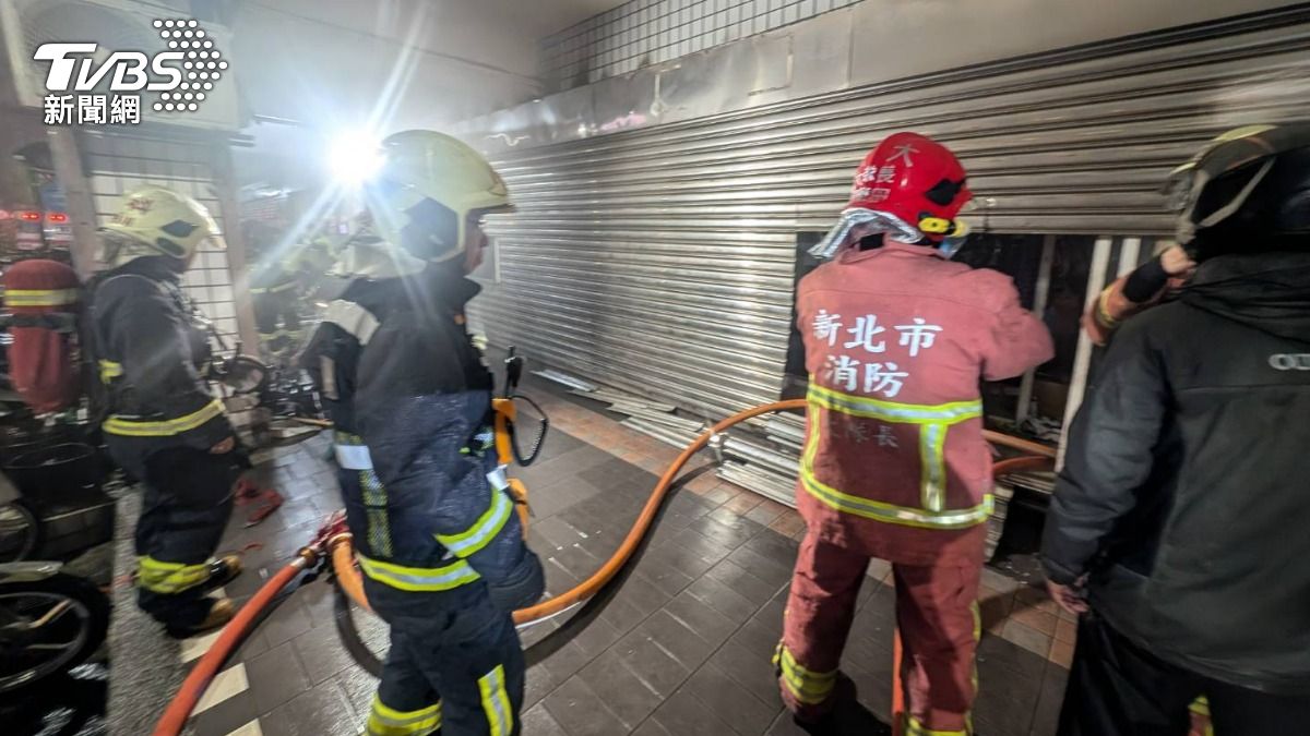 汐止寵物店暗夜發生火警,警消破壞鐵捲門入內搶救。(圖/TVBS)