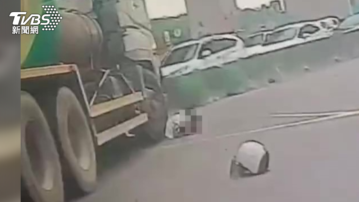婦人卡在水泥車右前輪下方,安全帽掉落一旁。(圖/TVBS)