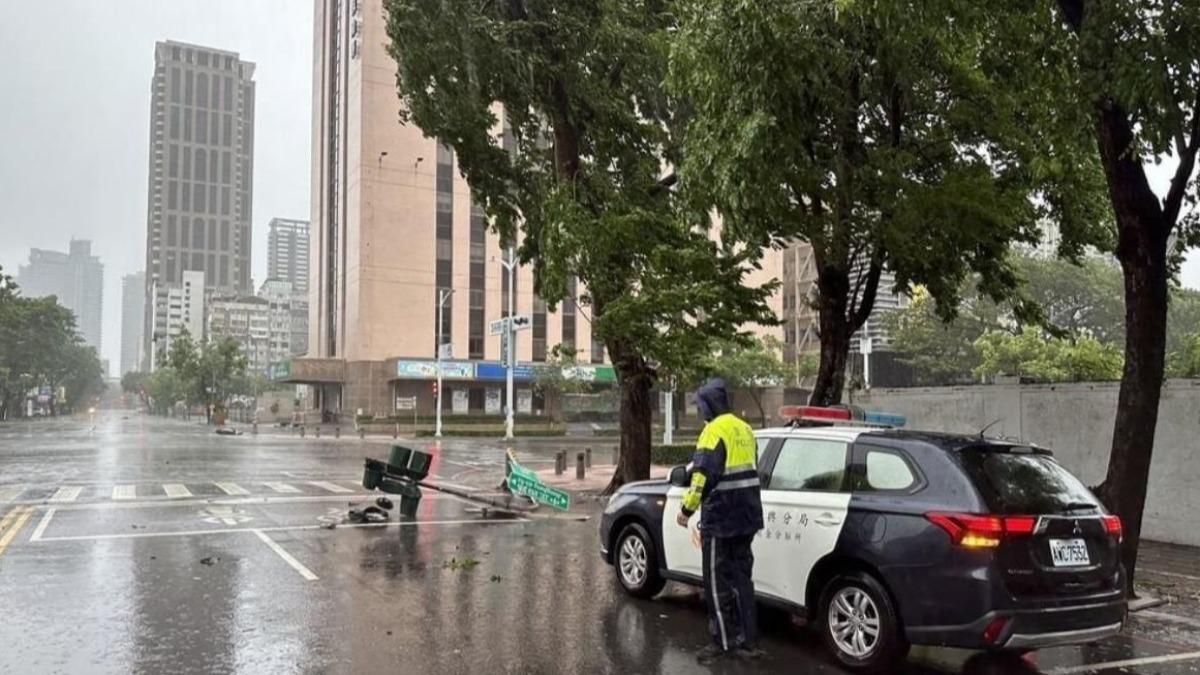 高雄3日上午風雨漸強,新興區中正四路與市中一路口號誌桿遭吹斷,員警到場管制。(圖/高市新興警分局提供)