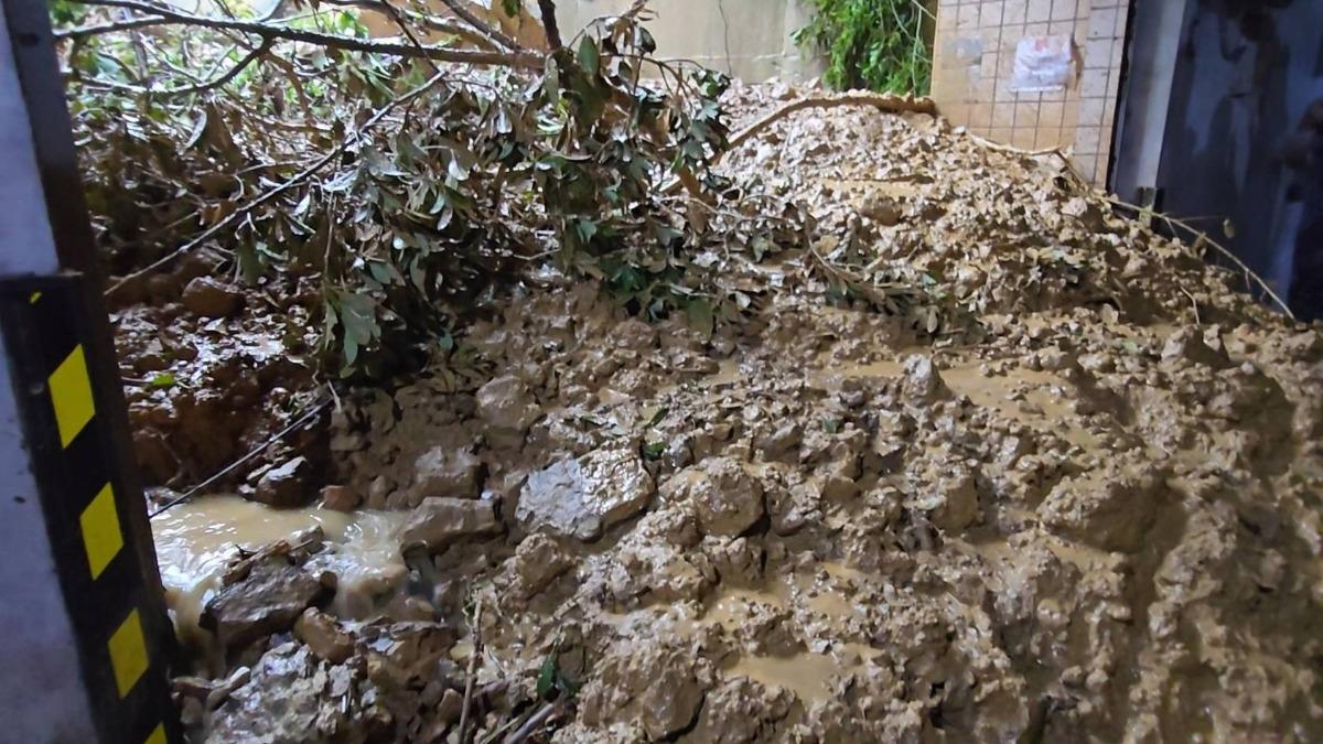 基隆市3日上午風急雨驟,調和街226巷一處社區「碧砂山水」後方山坡發生崩塌,土石流不僅沖入住家,更沿路面順勢而下堆積在社區停車場出入口。(圖/讀者提供)