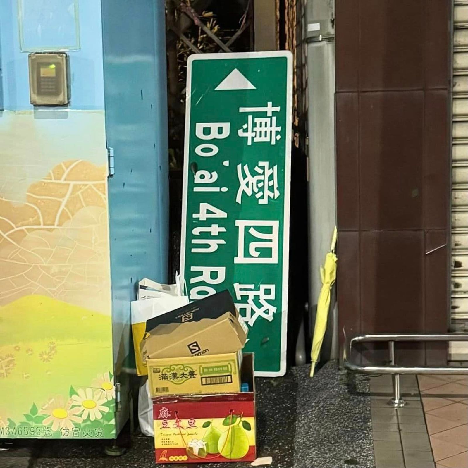 高雄人收拾家園之餘,與掉落的路牌合影。(圖/翻攝自高雄點臉書)