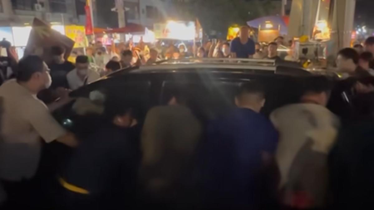 轎車旁出現了一群男子圍了一圈，並徒手將轎車拉起，緩緩移動到路邊。（圖／翻攝自爆料公社）