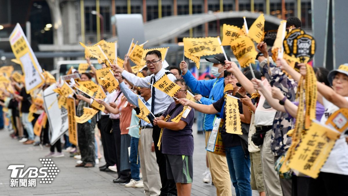 罷樑支持者在海洋廣場周邊街口舉牌,向路過民眾宣傳罷免案。(圖/胡瑞麒攝)