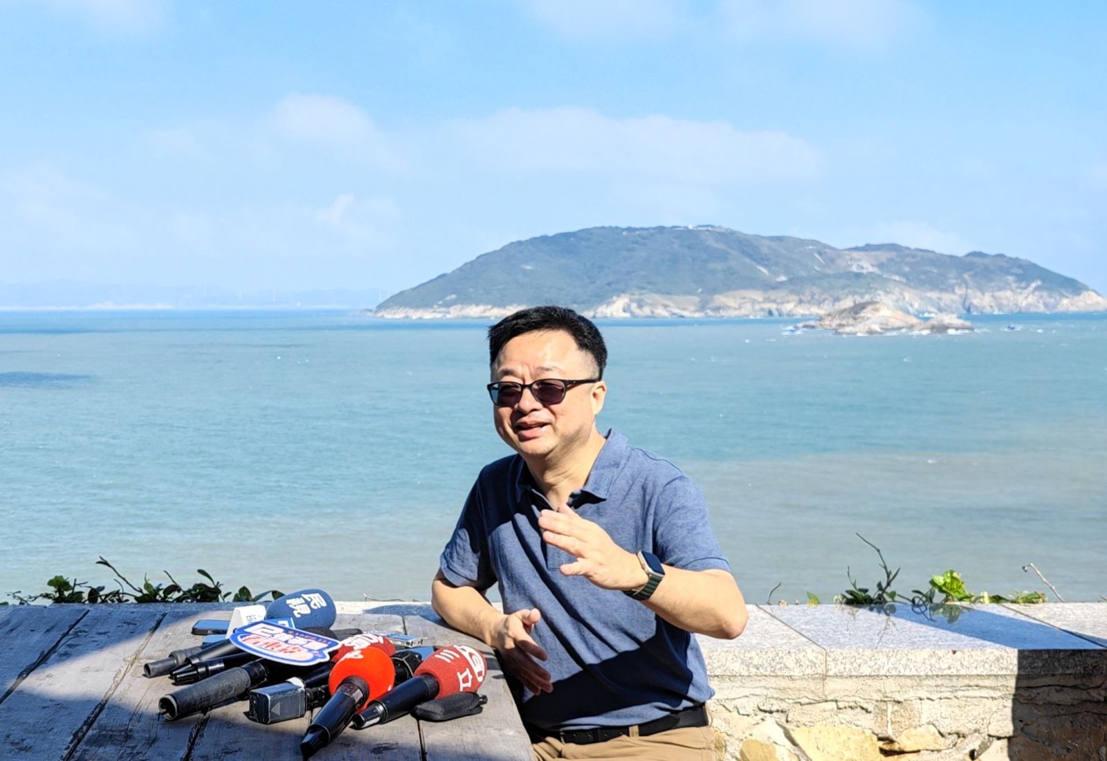 海基會秘書長羅文嘉在大坵島上受訪。後為高登島。(圖/海基會提供)