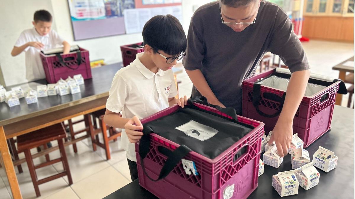 北市義方國小學生協助分裝鮮奶。(圖/北市教育局提供)