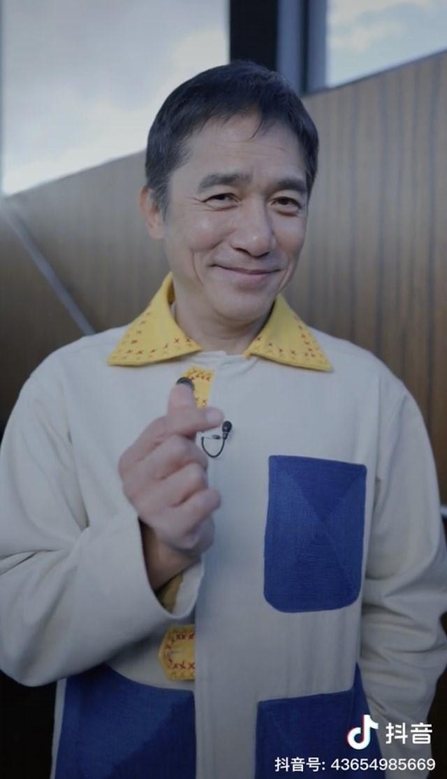 梁朝偉有3招克服社恐招數,就是:微笑、揮手和比心。(圖/翻攝自抖音)