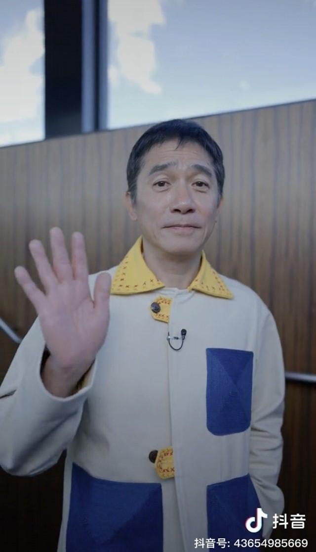 梁朝偉有3招克服社恐招數,就是:微笑、揮手和比心。(圖/翻攝自抖音)