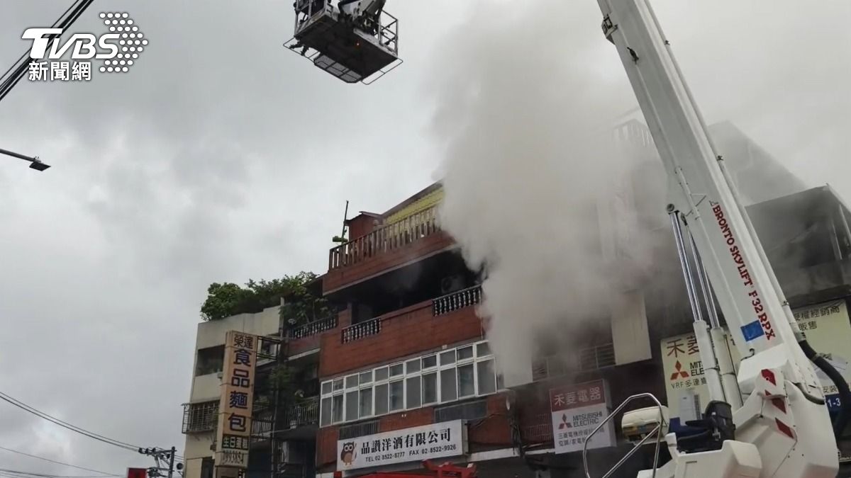 火警現場不斷地竄出濃煙,警消出動雲梯車救援。(圖/TVBS)