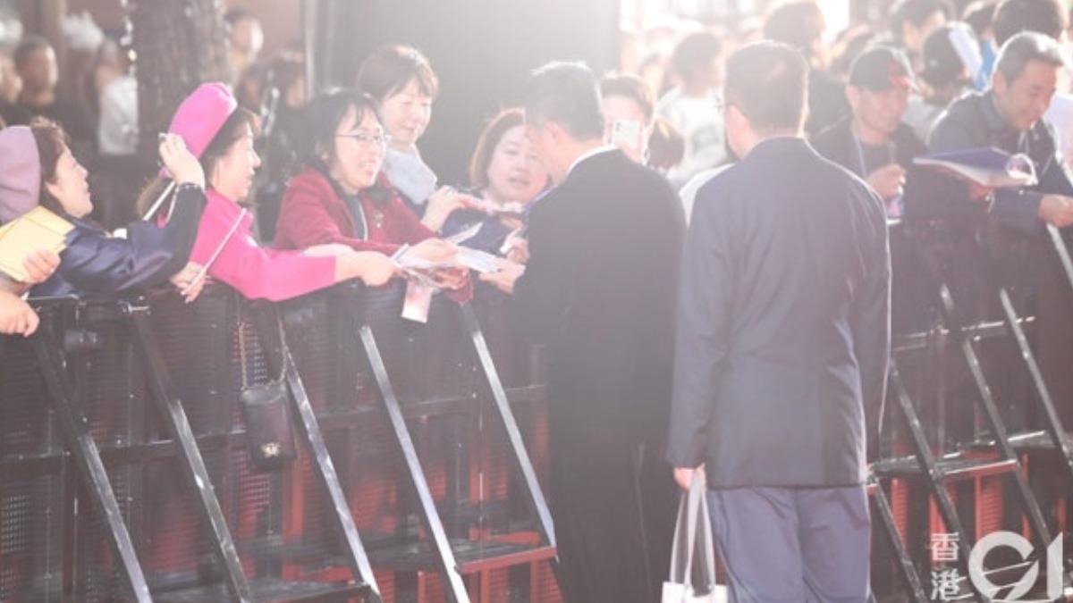 梁朝偉打破社恐面貌，於「第37屆東京國際電影節」紅地氈上為影迷簽名，表現親民。（圖／香港01）  