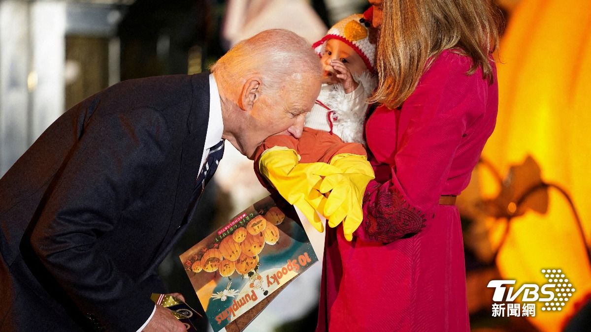 女子抱著裝扮成火雞的孩童上台時,拜登竟張口咬了大腿一口。(圖/達志影像路透社)