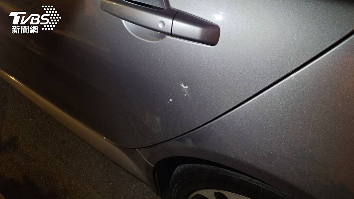 小轎車遭上方快速道路施工掉落的碎石砸中,車門板金凹陷、掉漆。(圖/TVBS)
