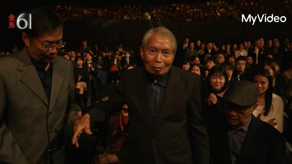 攝影師林文錦（右）由兒子攙扶走上台。（圖／翻攝MyVideo）