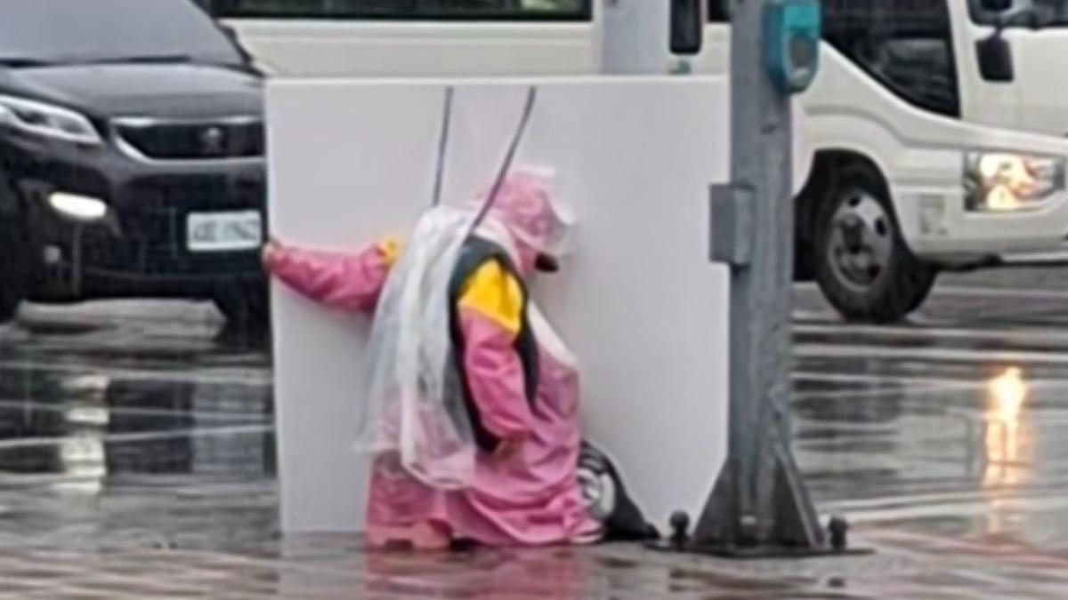 很多人努力活著!目睹路邊舉牌工「雨中撐廣告牌」 心酸畫面惹淚