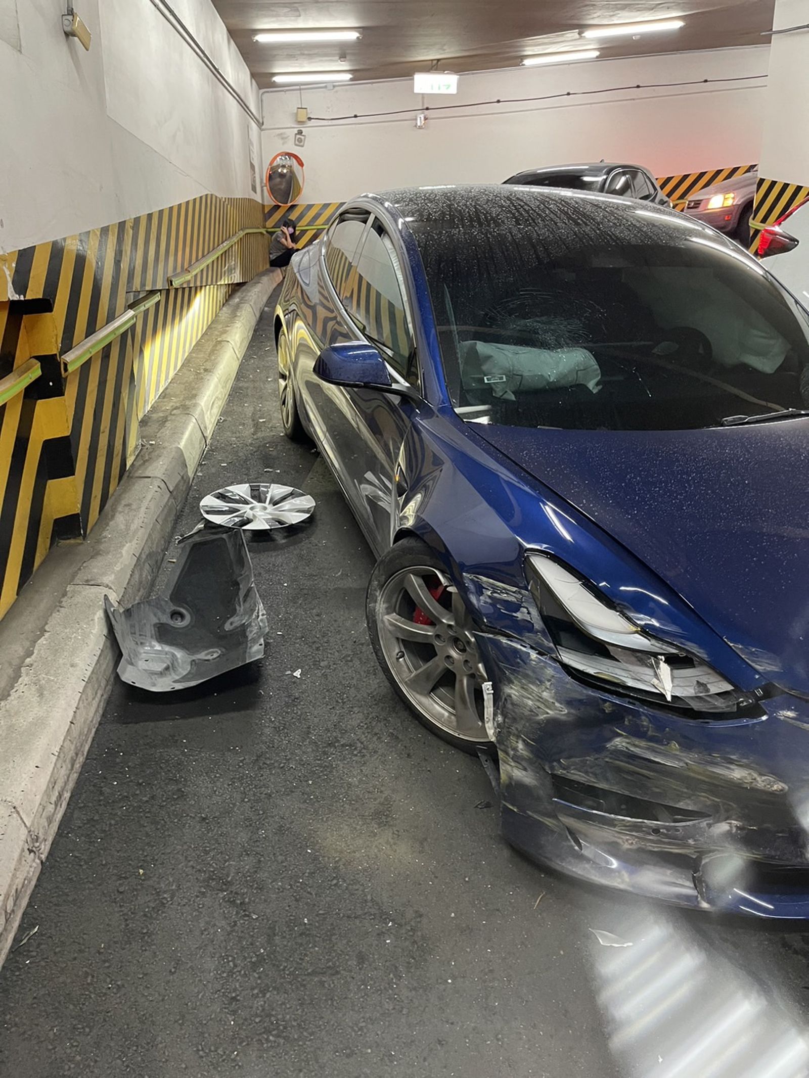 邱銘乾夫婦駕駛的特斯拉在地下停車場車道突然暴衝,導致車頭毀損。(圖/讀者提供)