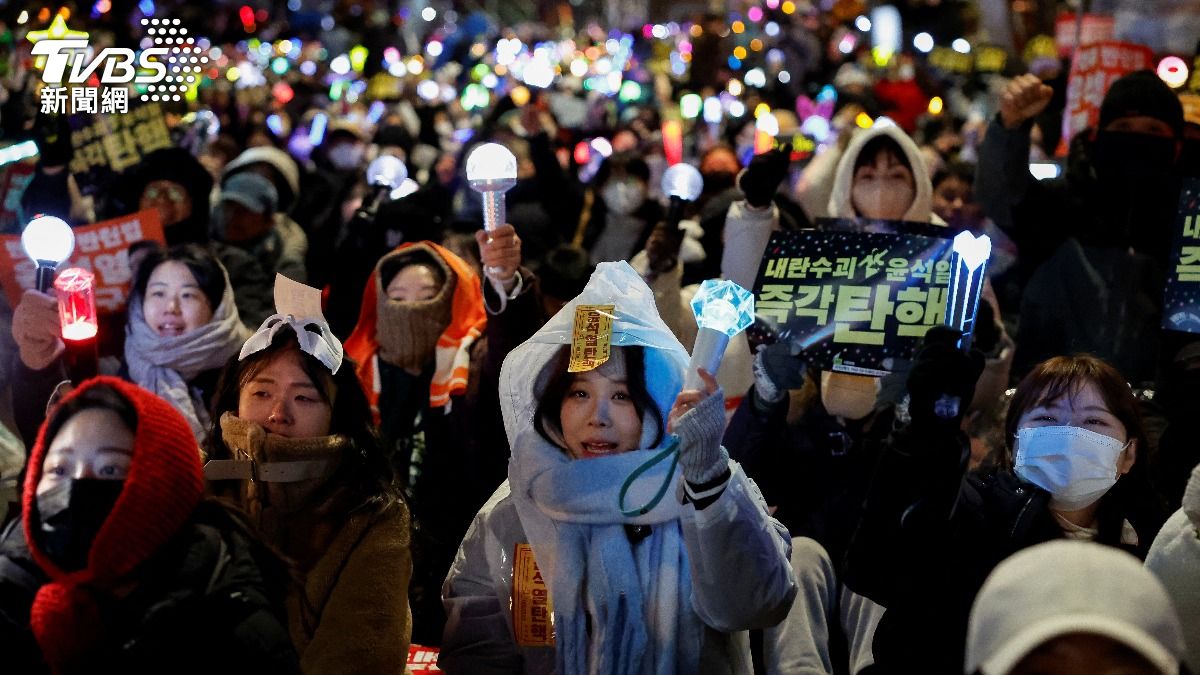 示威民眾拿著偶像的應援棒上街抗議。(圖/達志影像路透社)