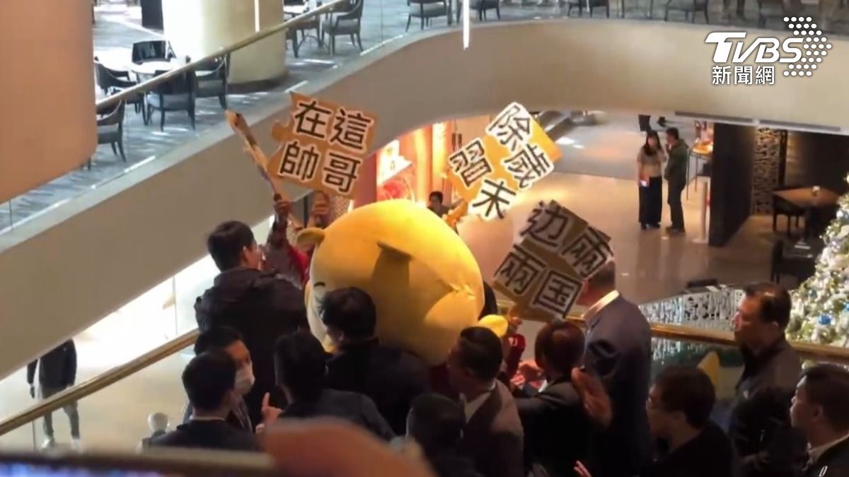有民眾穿著小熊維尼裝大鬧雙城論壇。(圖/TVBS)