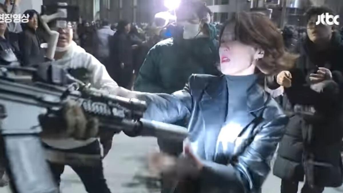 南韓共同民主黨發言人、前主播安貴朎抓戒嚴軍槍管。（圖／翻攝自 南韓媒體）
